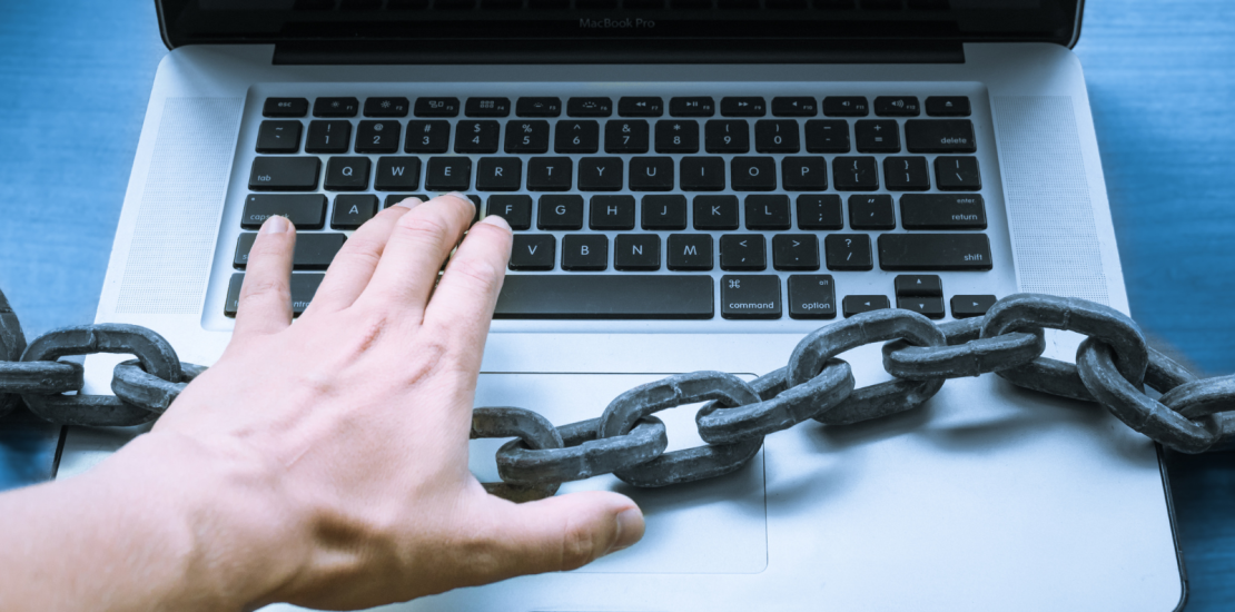 Person using laptop with a large chain across