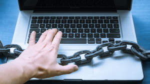 Person using laptop with a large chain across