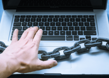 Person using laptop with a large chain across